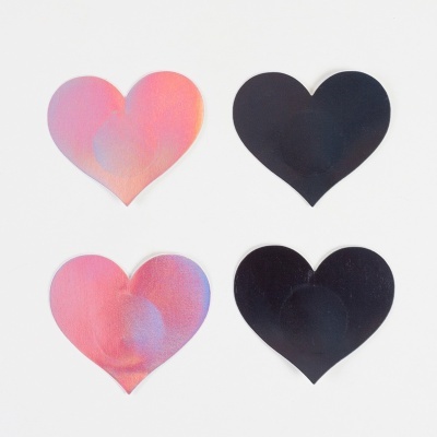Quatro corações recortados em papel, dois iridescentes rosa e dois pretos, sobre fundo branco