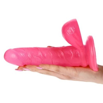 Dildo cor-de-rosa de silicone com base de ventosa segurado por mão