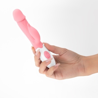 Vibrador cor de rosa e branco na mão contra fundo branco