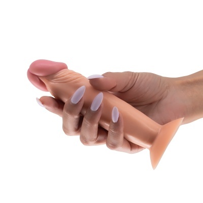 Mão feminina segurando objeto de silicone cor de pele com textura anatómica