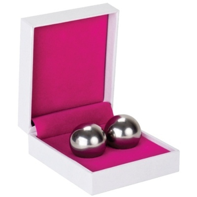 Duas bolas metálicas numa caixa branca com interior rosa