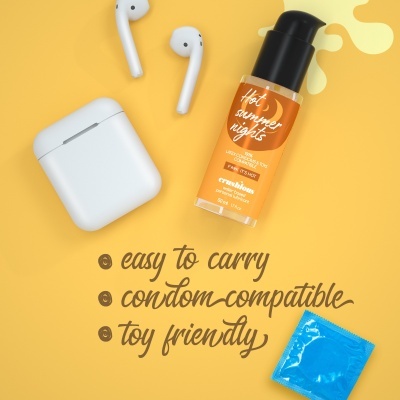 Frasco de lubrificante, auriculares brancos e preservativo azul sobre fundo amarelo