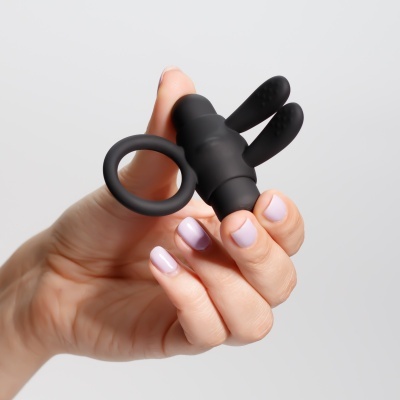 Dispositivo de silicone preto anatómico com anel a ser segurado por uma mão