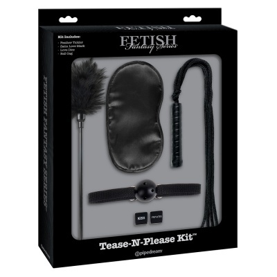 Conjunto Fetish Fantasy Series 'Tease-N-Please Kit' com pluminha, venda para olhos, chicote, dispositivo de boca, e fitas ajustáveis em embalagem preta e cinza.