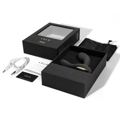 Caixa com produto íntimo em silicone preto, cabo USB, saco de veludo e manuais.