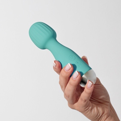 Vibrador azul turquesa com base metálica segurado pela mão