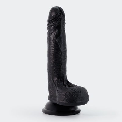 Dildo preto com ventosa na base sobre fundo branco