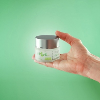 Frasco pequeno de VitoVit com tampa prateada segurado por uma mão