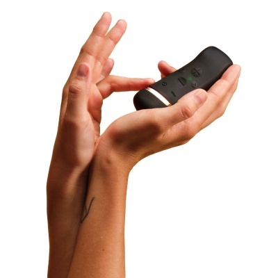 Comando remoto preto com botões, mãos seguram o comando