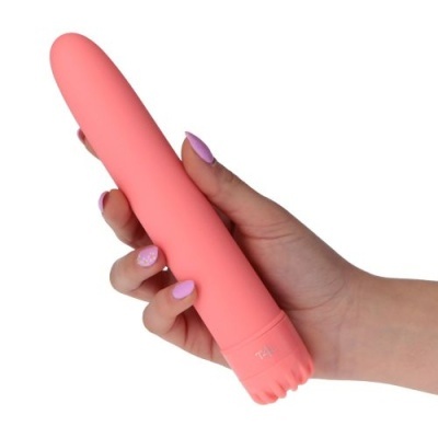 Vibrador rosa salmão de silicone com botão TPE na base segurado por uma mão