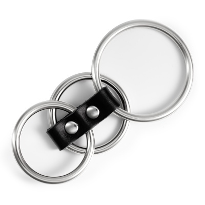 Conjunto de três anéis metálicos prateados ligados por tira preta de couro com tachas.