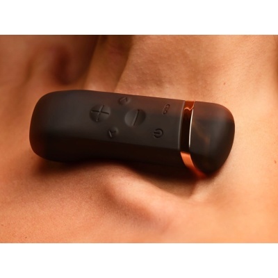 Comando remoto preto com botões sobre pele humana