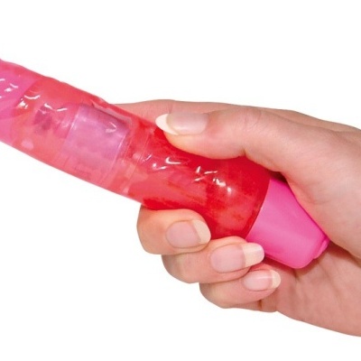 Vibrador rosa translúcido na mão com textura veias e botão rosa.