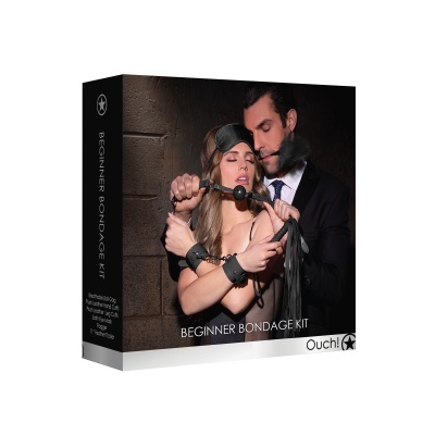 Caixa preta com kit 'BEGINNER BONDAGE KIT' da Ouch! mostrando casal com acessórios bondage pretos.