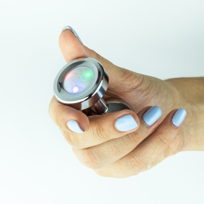 Mão segurando objeto metálico redondo com luzes LED coloridas