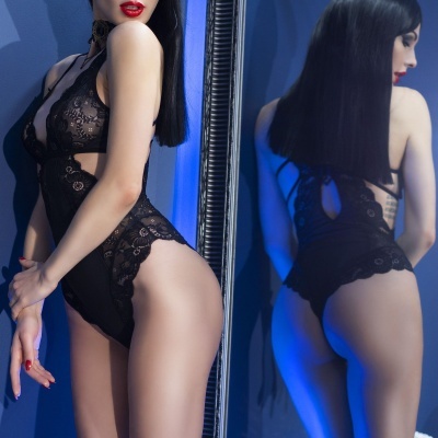 Body feminino de renda preta com padrão floral refletido num espelho