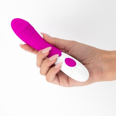 Vibrador rosa e branco segurado por mão feminina