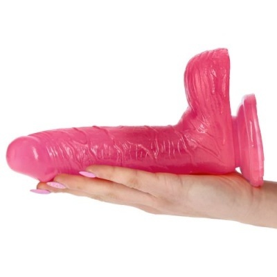 Dildo rosa com base de sucção e textura realista na mão de uma pessoa.