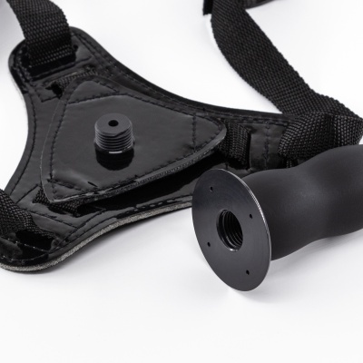 suporte triangular preto com tiras de tecido e peça cilíndrica destacada