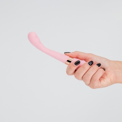 Mão segurando um vibrador rosa