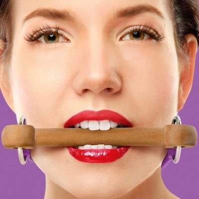 Mulher com batom vermelho segurando objeto cilíndrico de madeira