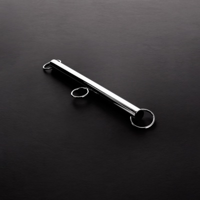 Barra metálica cromada com três argolas sobre fundo preto