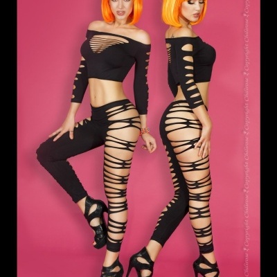 Conjunto preto com cortes horizontais em mulher com peruca laranja em fundo rosa