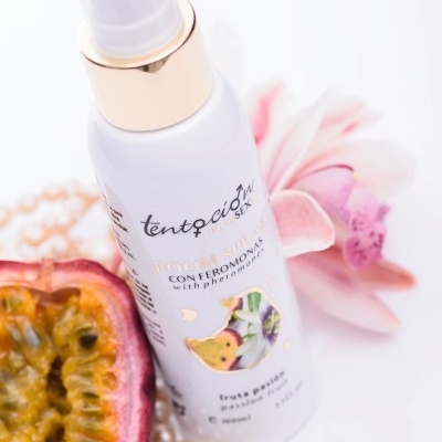 Frasco branco de spray com maracujá, pérolas e flor rosa