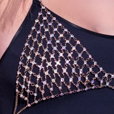 Colar de rede dourada com pedras brilhantes sobre roupa preta