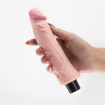 Vibrador realista cor de pele com base preta e ponta rosada segurado por uma mão