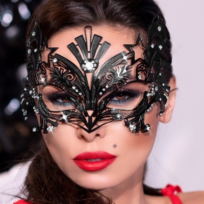 Máscara facial preta decorativa com estrelas usada numa mulher de lábios vermelhos