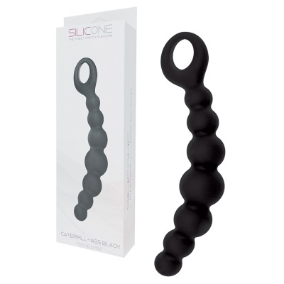 Brinquedo adulto preto de silicone com bolinhas e argola, e embalagem branca com texto.