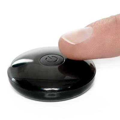 Comando remoto redondo preto com botão de power e dedo a pressioná-lo