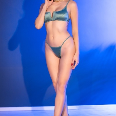 Mulher com lingerie verde acetinada e saltos altos verdes