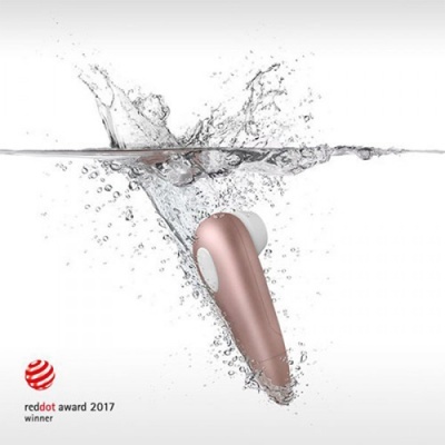 Dispositivo electrónico rosa com ponta branca submerso em água com bolhas.