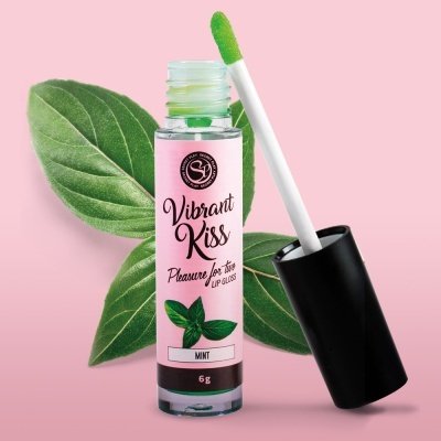 Gloss labial verde com aplicador e folhas verdes ao fundo