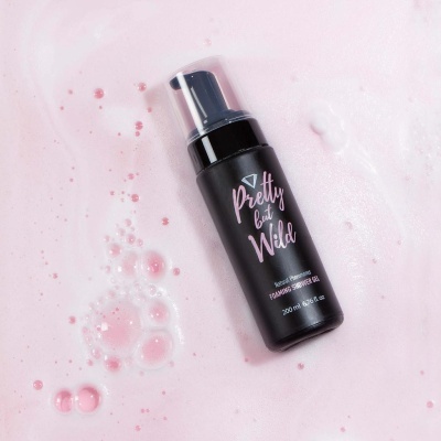 Frasco preto de espuma de limpeza facial sobre espuma rosa