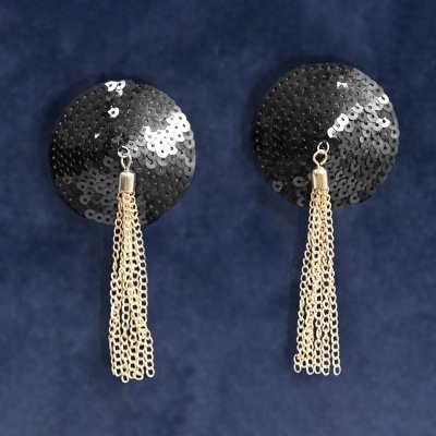 Brincos com discos pretos de lantejoulas e franjas douradas em correntes.