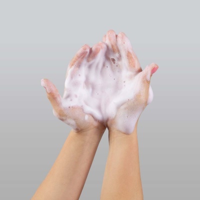 Mãos com espuma branca cremosa