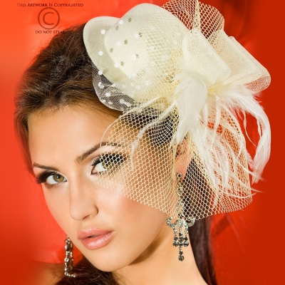 Mulher com fascinator branco decorado com pérolas, rede e penas