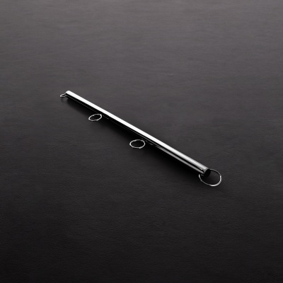 Objeto metálico cilíndrico com três argolas numa superfície preta