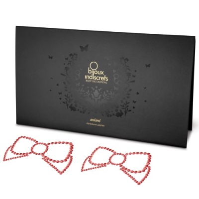 Adesivos corporais em forma de laço com pedras cor de rosa, embalagem preta com logótipo dourado.