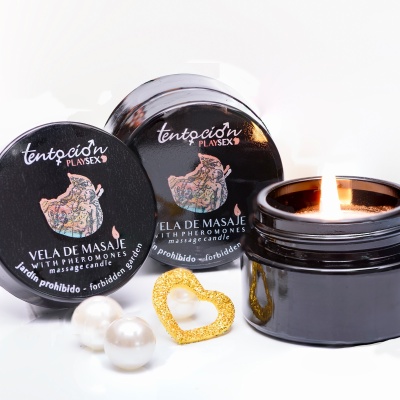 Vela de massagem preta com tampa, pérolas brancas e anel dourado em fundo branco