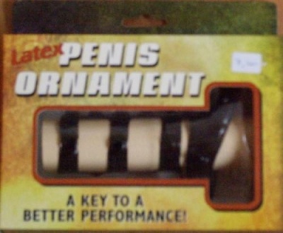 Ornamento em látex em forma de pénis numa caixa amarela com texto em inglês.
