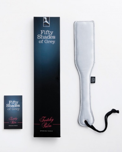 Paddle branco de couro com embalagem 'Fifty Shades of Grey' sobre fundo branco