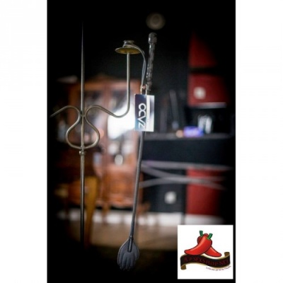 Colher de silicone preta com cabo metálico pendurada num suporte