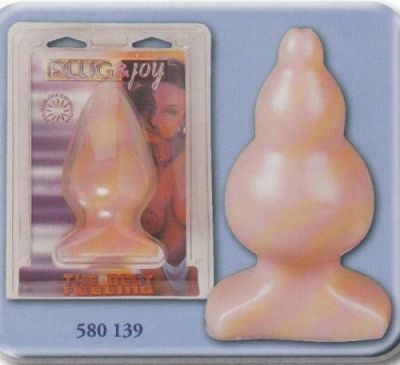 Plug anal de silicone cor de pele na embalagem transparente com texto PLUG joy e THE REAL FEELING