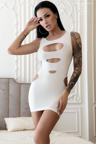 Mulher a usar vestido branco justo com recortes ovais em ambiente interior decorativo