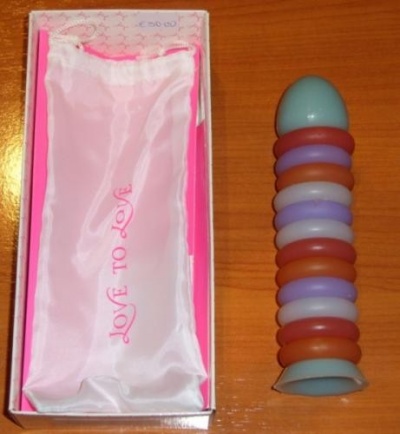 Caixa com saco de tecido rosa e objeto azul claro com anéis coloridos em madeira