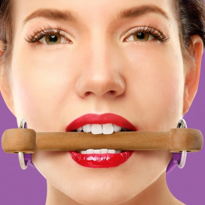 Mulher com batom vermelho segurando objeto cilíndrico de madeira